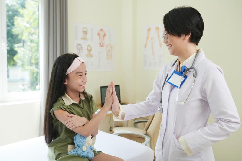 a pediatrician highfiving a girl