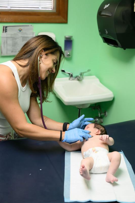 a female provider looking at a baby on a table