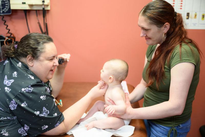 a provider looking at a baby on a table