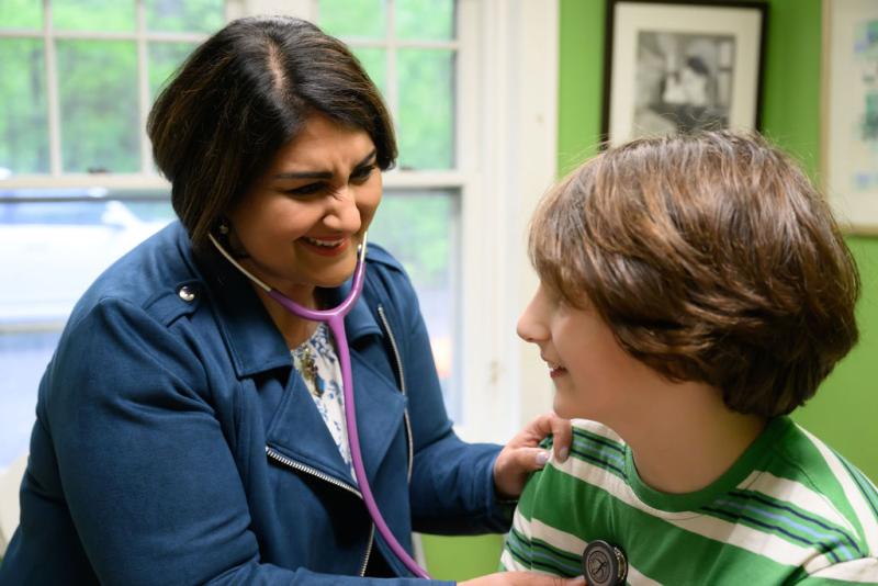 a medical provider smiling at a teenage boy
