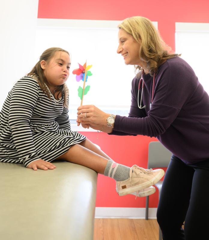 a pediatrician holding a flower to a patient