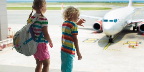 two children looking out the window at an airplane