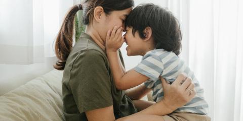 a young boy sitting on his mothers lap