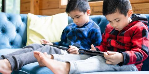 two boys playing on electronic devices