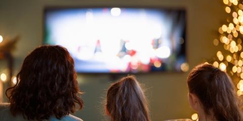 a mother and daughters in front of a television